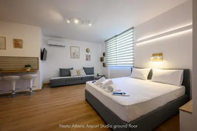 a bedroom with a king sized bed and a couch at Nesto Athens Airport Zen in Spáta