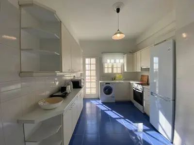 a kitchen with white cabinets and a blue floor at 2-bedroom apartment in Athina (Filopappou) in Athens