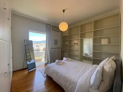 a bedroom with a large white bed and shelves at 2-bedroom apartment in Athina (Filopappou) in Athens