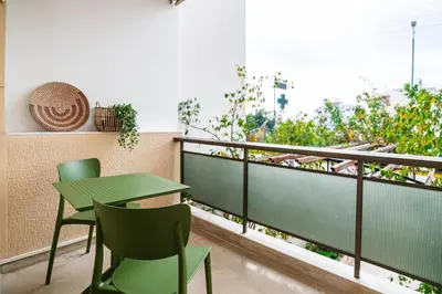 a green table and chairs on a balcony with a view at AlMar- Διαμέρισμα στο κέντρο της Ηλιούπολης in Athens