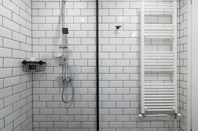 a bathroom with a shower with white tiled walls at Luxury 1-Bedroom Apartment by the Sea in Athens in Athens
