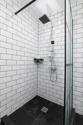 a bathroom with a shower with white tile walls at Luxury 1-Bedroom Apartment by the Sea in Athens in Athens