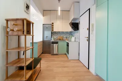 a kitchen with green and white appliances and wooden floors at Luxury 1-Bedroom Apartment by the Sea in Athens in Athens