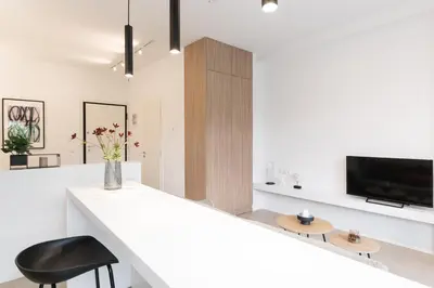 a white kitchen with a white counter and a black chair at Voda Luxury Residence #101 - Acropolis View Rooftop in Athens