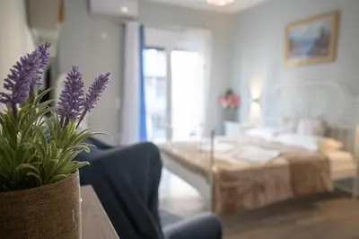 a living room with a couch and a table with purple flowers at Athens center 2 persons flat by MPS in Athens