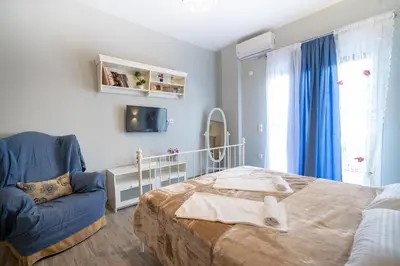 a bedroom with a bed and a blue chair at Athens center 2 persons flat by MPS in Athens