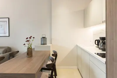 a white kitchen with a wooden table and chairs at Voda Luxury Residence #102 - Acropolis View Rooftop in Athens