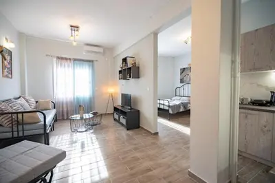 a living room with a couch and a tv in a room at Athens center 1 bedrm 4 pers apartment by MPS in Athens