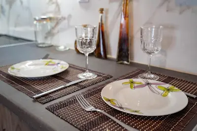 a table with two plates and wine glasses on it at Athens center 1 bedrm 4 pers apartment by MPS in Athens