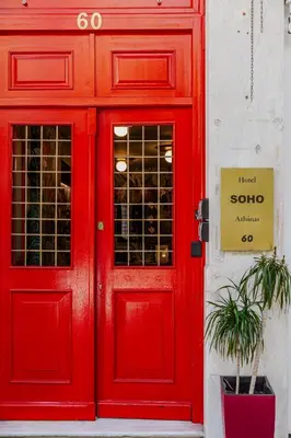 a red door of a store with a sign on it at SoHo Athinas 60 in Athens