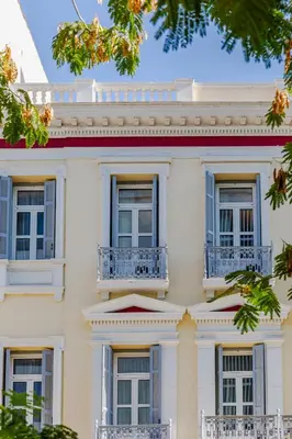 a white house with blue windows and trees at SoHo Athinas 60 in Athens
