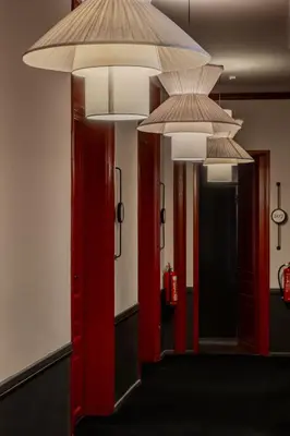 a hallway with red doors and chandeliers at SoHo Athinas 60 in Athens