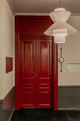 a red door in a room with a chandelier at SoHo Athinas 60 in Athens