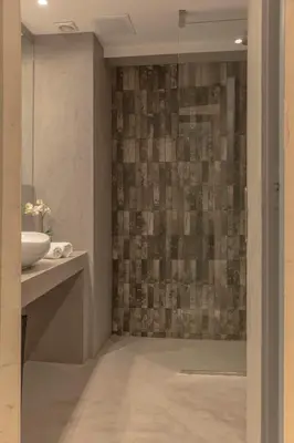 a bathroom with a glass shower with a sink at Living Stone Bronze in Athens