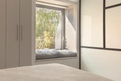 a window seat in a bedroom with a view of a tree at Living Stone Bronze in Athens
