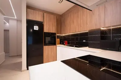 a kitchen with a black refrigerator and wooden cabinets at Athens Hippest Apartment in Athens