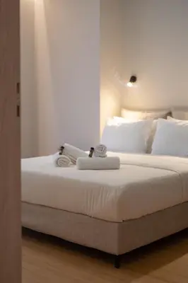 a bedroom with a bed with two towels on it at Athens Hippest Apartment in Athens