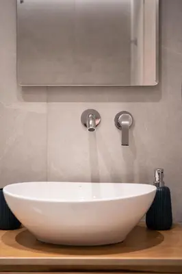 a white sink on a wooden counter with a mirror at Athens Hippest Apartment in Athens