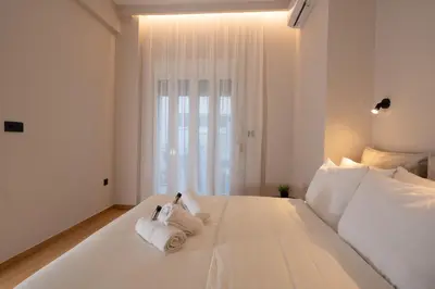 a bedroom with a white bed with towels on it at Athens Hippest Apartment in Athens
