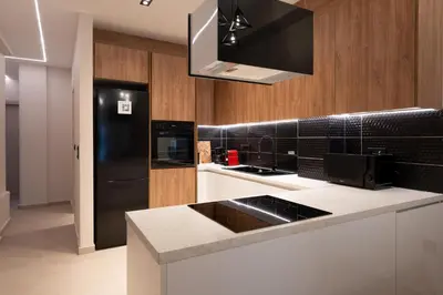 a kitchen with a black refrigerator and white counter tops at Athens Hippest Apartment in Athens