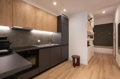 a kitchen with black appliances and wooden cabinets at Unique 2 Bedrooms Apartment, Steps to Plaka and City center in Athens