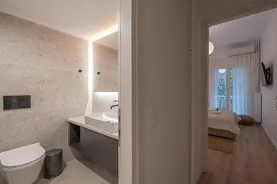 a bathroom with a sink and a toilet and a bedroom at Unique 2 Bedrooms Apartment, Steps to Plaka and City center in Athens