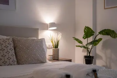 a bedroom with a bed with a plant and a lamp at Unique 2 Bedrooms Apartment, Steps to Plaka and City center in Athens
