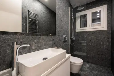 a bathroom with a white sink and a toilet at Unique 2 Bedrooms Apartment, Steps to Plaka and City center in Athens