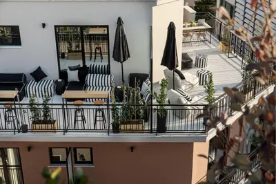 a balcony with couches and umbrellas at Clyde Athens by Nin&Bau in Athens