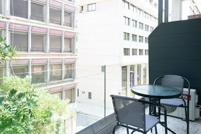 a table and chair on a balcony with a building at Voda Luxury Residence #201 - Acropolis View Rooftop in Athens