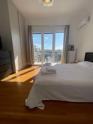 a bedroom with a large bed and a large window at PAGRATI FLAT 7 in Athens