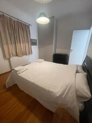 a bedroom with a large white bed in a room at PAGRATI FLAT 7 in Athens