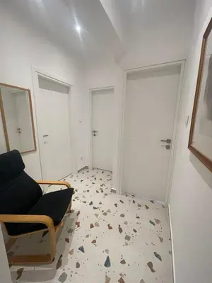 an empty room with a chair and two doors at PAGRATI FLAT 7 in Athens