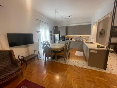 a kitchen and living room with a table and a kitchen and a dining room at PAGRATI FLAT 7 in Athens