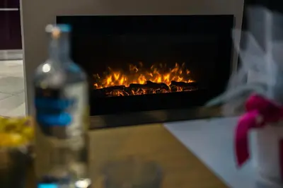 a bottle of wine sitting next to a fireplace at 