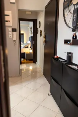 a hallway with a room with a bed and a clock at 