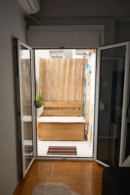 a view of a room with a bench through a glass door at 