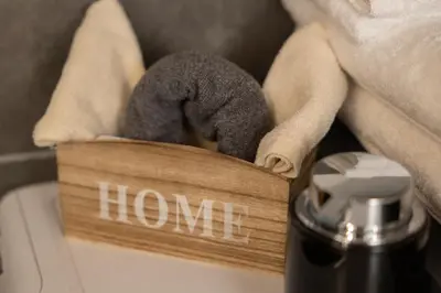 a wooden block with the word home on it next to a towel at 