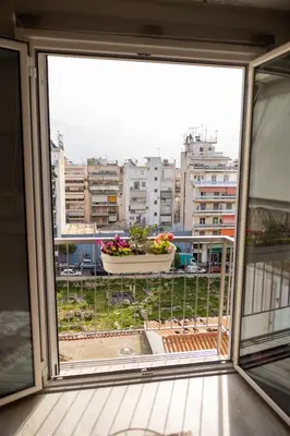 a window with a pot of flowers on a balcony at 