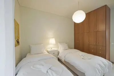 a bedroom with two beds with white sheets at LucyZen! Stylish Apt, Athenian Riviera, near beach in Athens