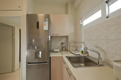 a kitchen with a stainless steel refrigerator and a sink at LucyZen! Stylish Apt, Athenian Riviera, near beach in Athens
