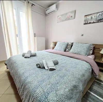 a bedroom with a large bed with towels on it at Elpida's house in Spáta