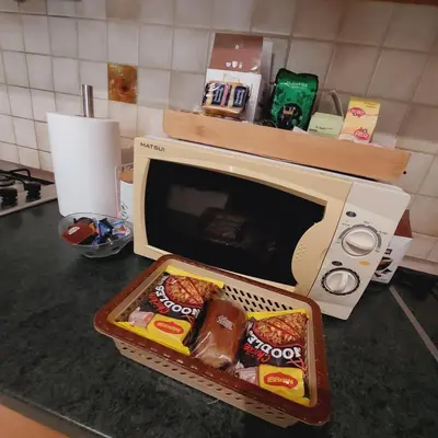 a microwave sitting on a kitchen counter with food inside at Elpida's house in Spáta