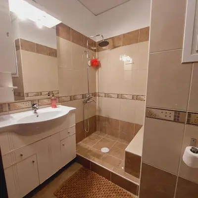 a bathroom with a sink and a shower at Elpida's house in Spáta