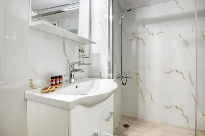 a white bathroom with a sink and a shower at Nemesis - Elegant apartment in Athens in Athens