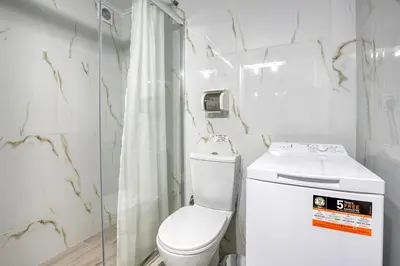 a white bathroom with a toilet and a shower at Nemesis - Elegant apartment in Athens in Athens