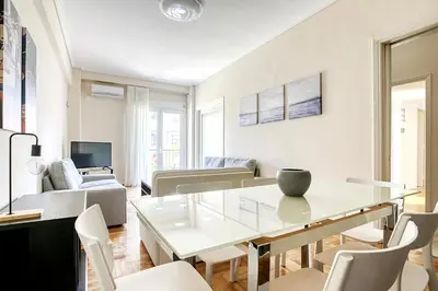 a white living room with a table and chairs at Nemesis - Elegant apartment in Athens in Athens