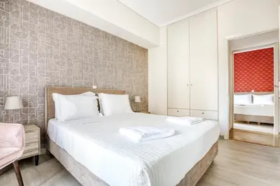 a bedroom with a large bed and a red window at Nemesis - Elegant apartment in Athens in Athens