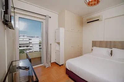 a bedroom with a bed and a glass table at Cozy & Relaxing Apartments-Agia Paraskevi in Athens