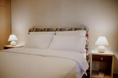 a bedroom with a white bed with two lamps at Cozy & Relaxing Apartments-Agia Paraskevi in Athens